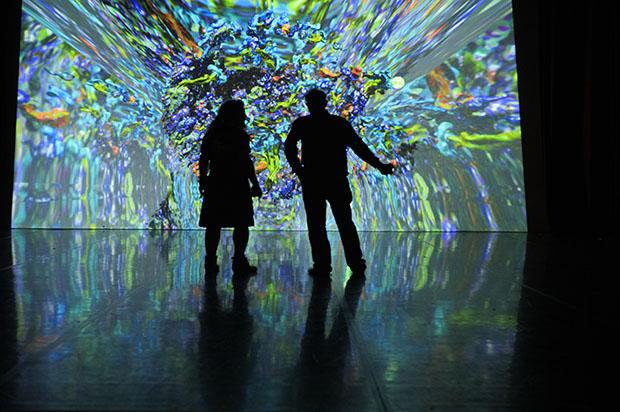 silhouette images in front of large computer screen